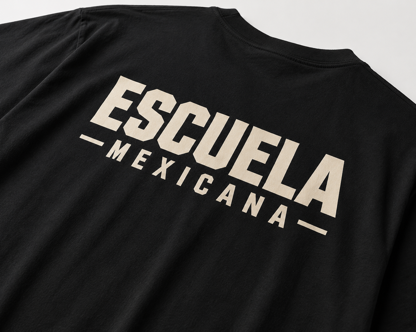 Close-up of Escuela Mexicana back graphic on black cotton